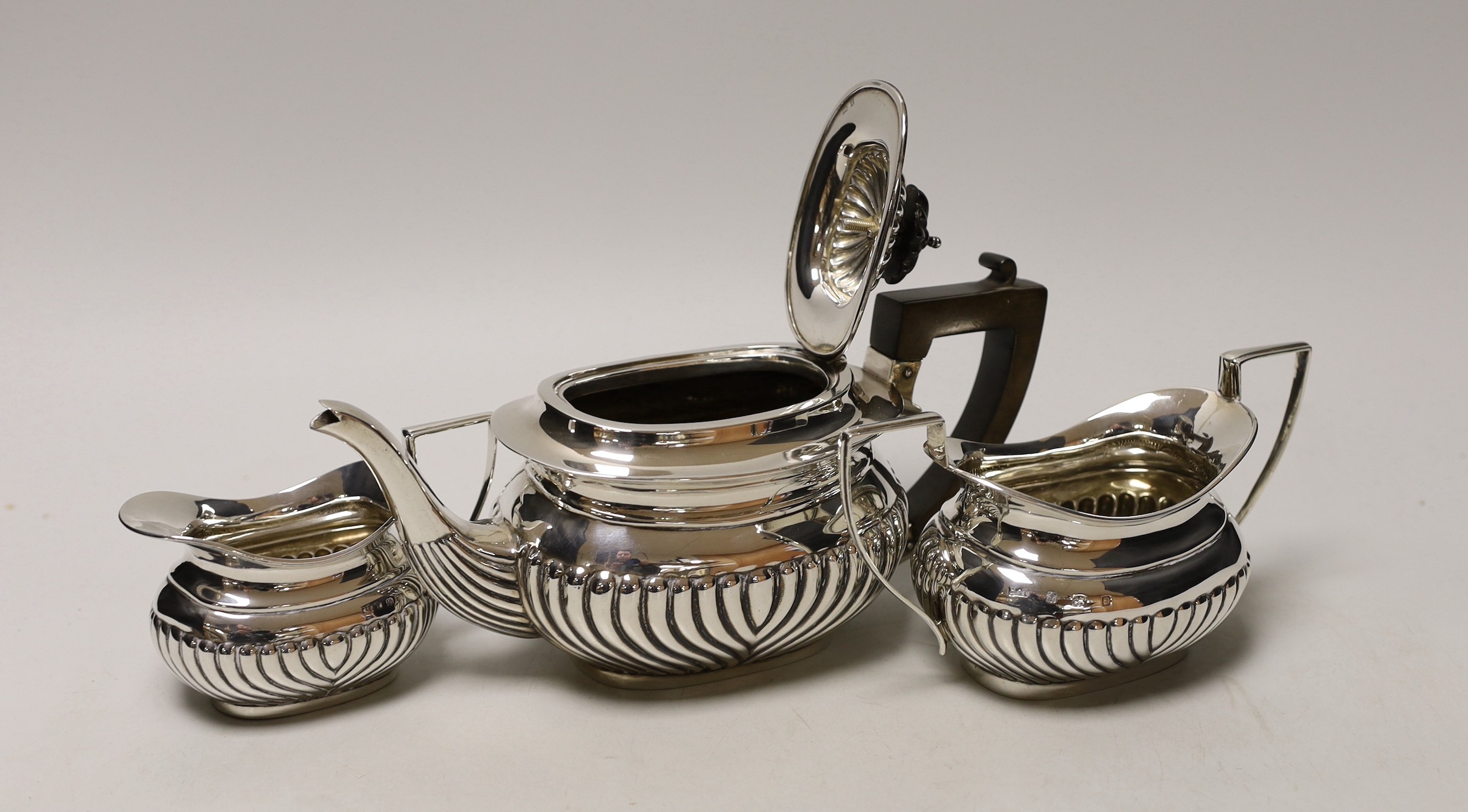 An Edwardian three piece demi-fluted silver tea set, Birmingham, 1905, gross 21.1oz.